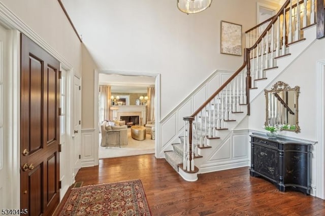 entrance foyer with stairs, dark wood-style flooring, and a decorative wall