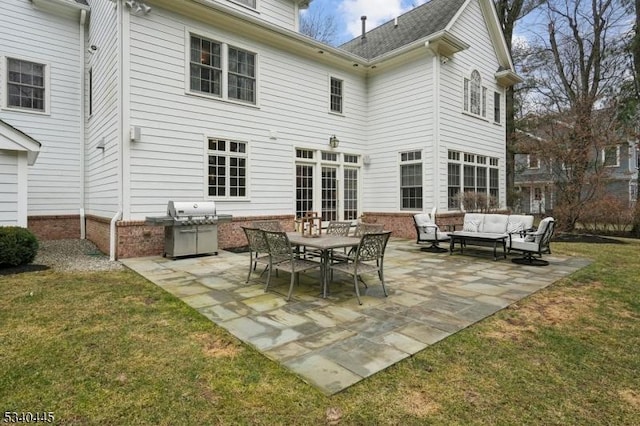 rear view of house featuring outdoor lounge area, a patio area, and a lawn