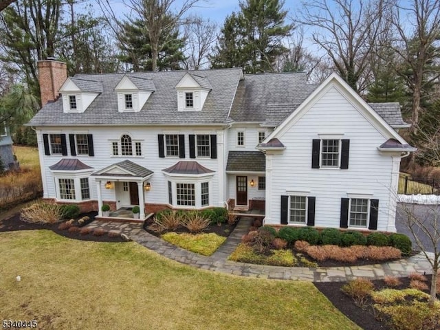 view of front facade featuring a front yard and a chimney