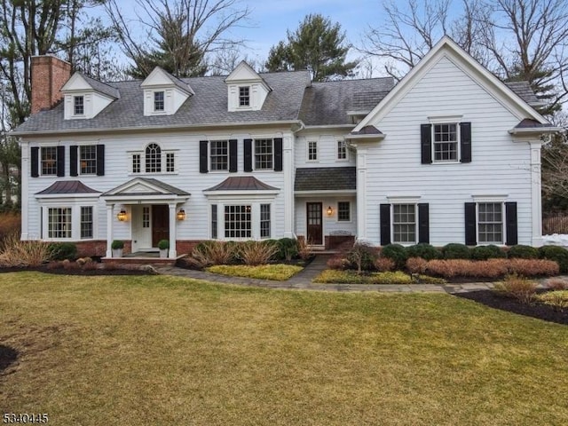 view of front of house with a chimney and a front yard