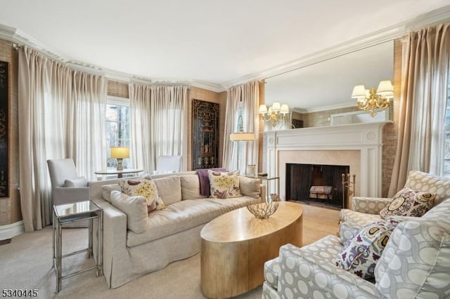 sitting room with a chandelier, carpet flooring, ornamental molding, and a fireplace