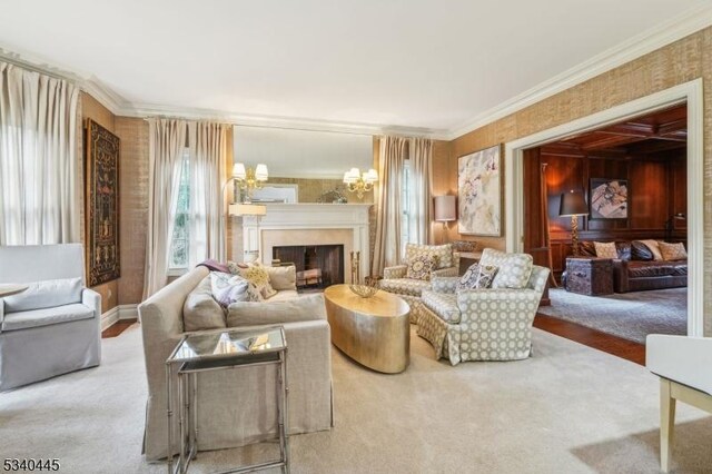 sitting room with crown molding, a notable chandelier, carpet flooring, and a fireplace