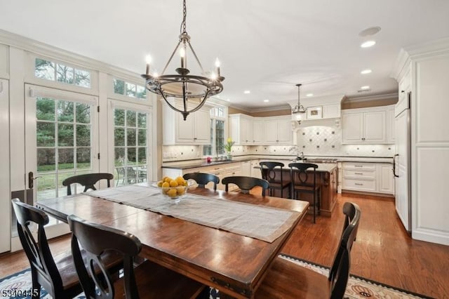 dining room featuring recessed lighting, a notable chandelier, wood finished floors, and crown molding