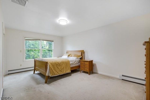 bedroom with a baseboard heating unit, visible vents, light carpet, and baseboards