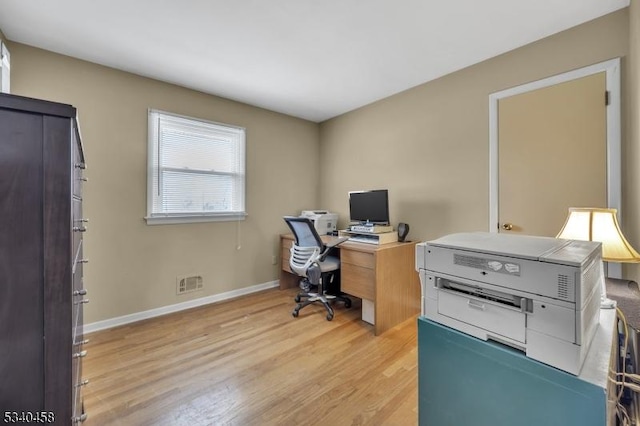 office with light wood-style flooring, visible vents, and baseboards