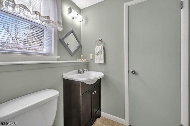 bathroom with baseboards, vanity, and toilet