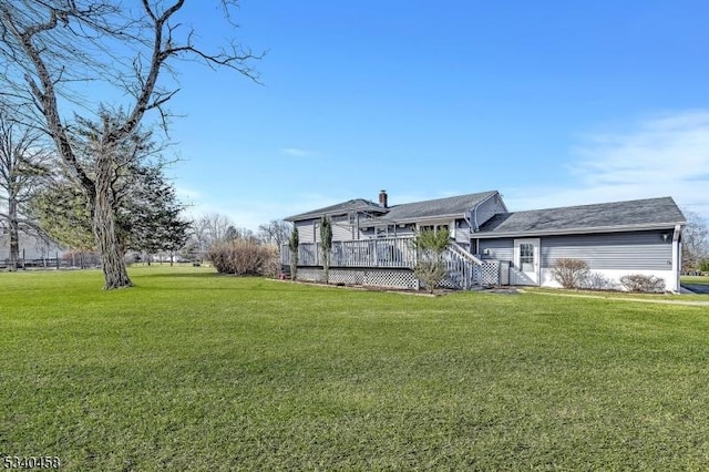 rear view of house featuring a deck and a yard