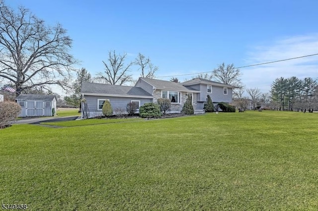 tri-level home with a shed, an outdoor structure, and a front yard