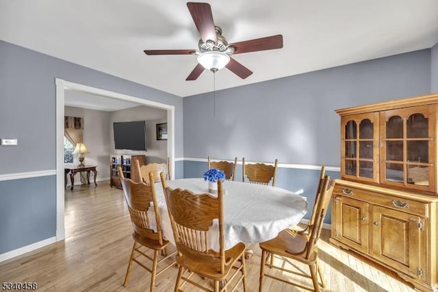 dining area with a ceiling fan, baseboards, and light wood finished floors