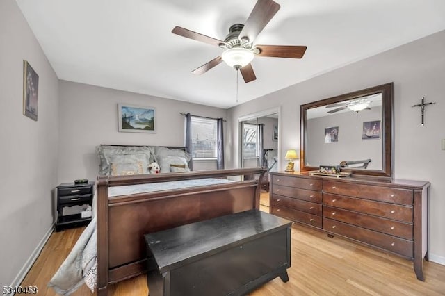 bedroom featuring light wood-style floors, ceiling fan, and baseboards