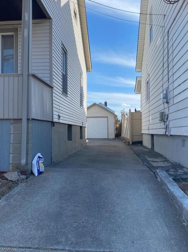 view of property exterior with aphalt driveway, an outdoor structure, and a garage