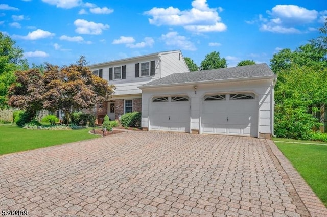 view of front of house featuring a front lawn, decorative driveway, and an attached garage