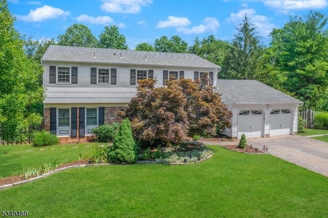 view of front of house featuring a front lawn, decorative driveway, an attached garage, and brick siding