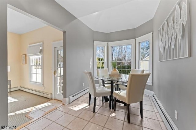 dining room featuring light tile patterned floors, baseboard heating, a baseboard radiator, and baseboards