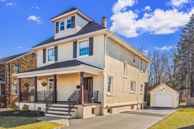 american foursquare style home featuring a chimney, covered porch, a garage, driveway, and an outdoor structure