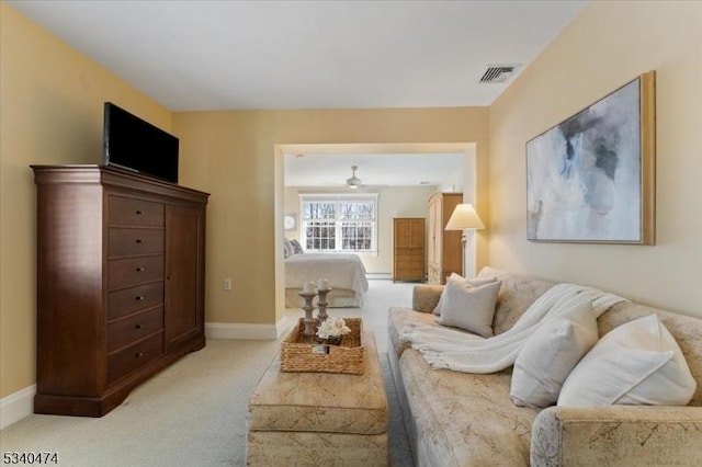 living room with baseboards, visible vents, and light colored carpet