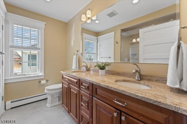 bathroom featuring a baseboard heating unit, a wealth of natural light, a sink, and visible vents