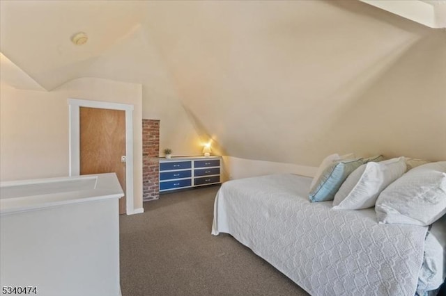 bedroom featuring lofted ceiling and dark carpet