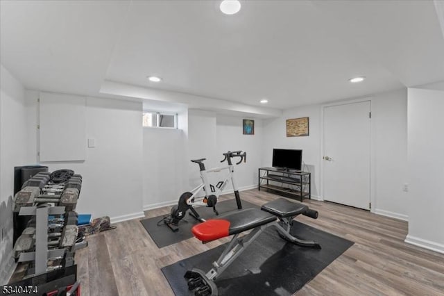 exercise area with baseboards and wood finished floors