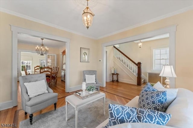 living area with a healthy amount of sunlight, crown molding, stairway, and wood finished floors