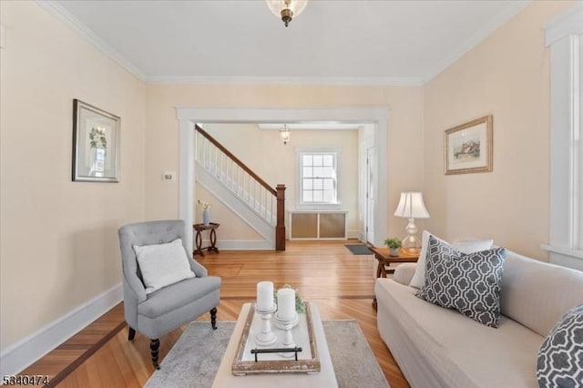 sitting room with baseboards, stairway, wood finished floors, and crown molding