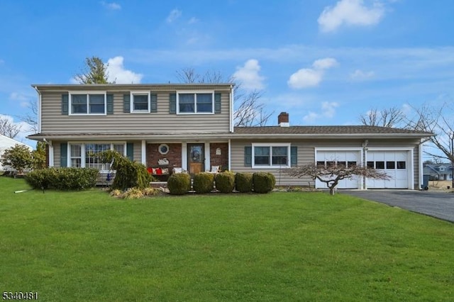 traditional-style home featuring a garage, driveway, and a front yard