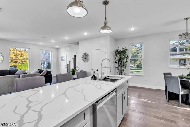 kitchen featuring recessed lighting, wood finished floors, a sink, and decorative light fixtures