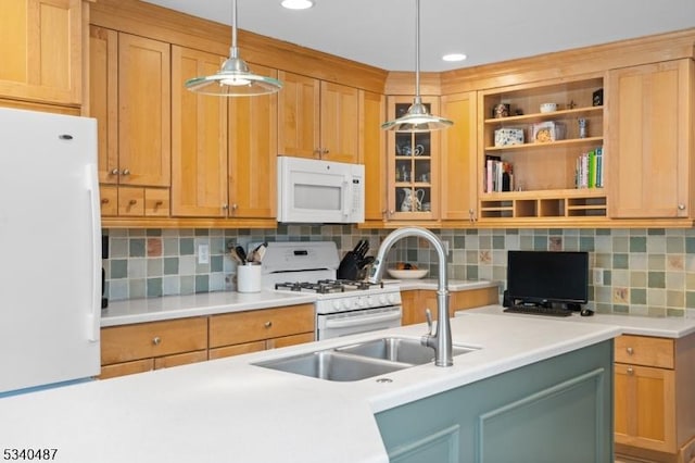 kitchen featuring light countertops, white appliances, a sink, and pendant lighting