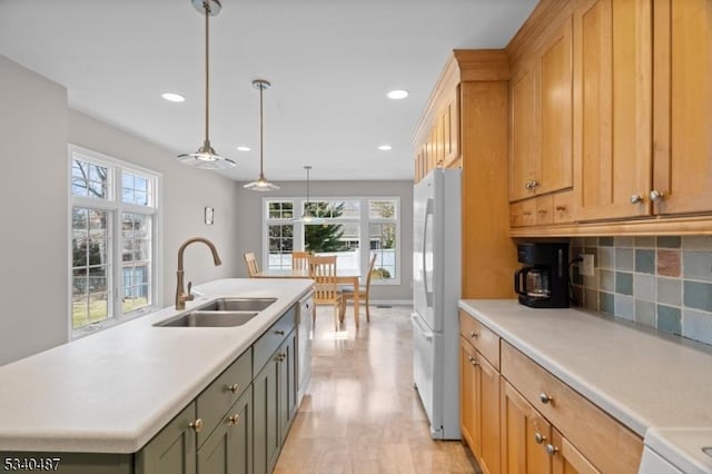 kitchen featuring light countertops, a sink, and freestanding refrigerator