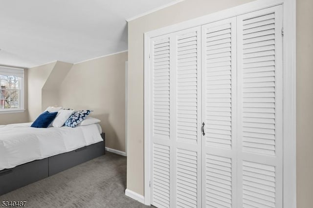 bedroom featuring baseboards, a closet, carpet flooring, and crown molding