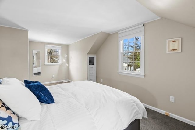 carpeted bedroom with lofted ceiling and baseboards