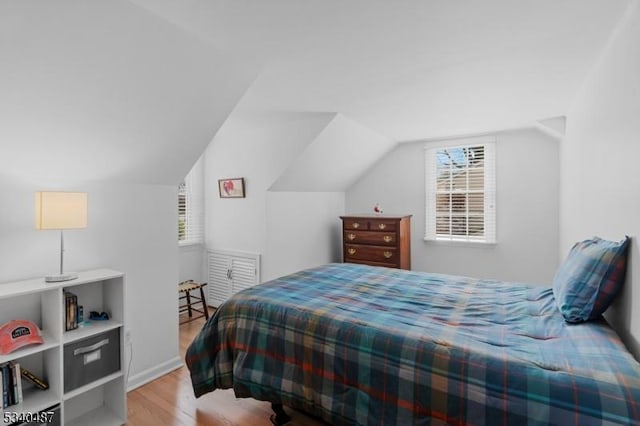 bedroom featuring lofted ceiling and wood finished floors