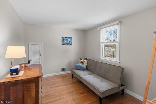 sitting room featuring light wood-type flooring, baseboards, and visible vents