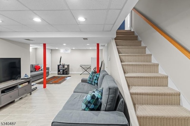 staircase with wood finished floors, a drop ceiling, and recessed lighting