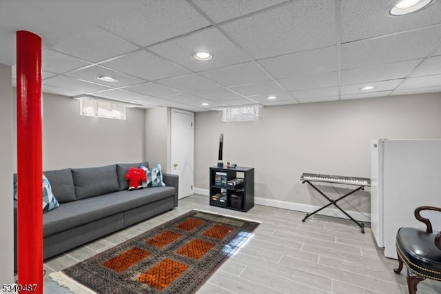 living room featuring a paneled ceiling, wood finished floors, baseboards, and recessed lighting