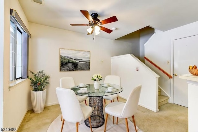 dining space with carpet, stairway, ceiling fan, and baseboards