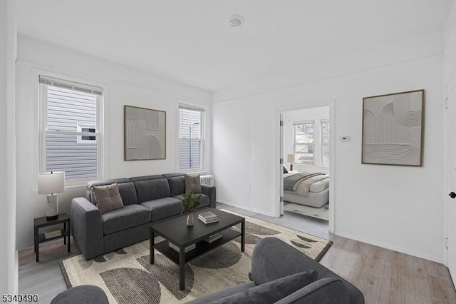 living room with light wood finished floors, baseboards, and a wealth of natural light