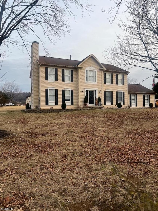 view of front of property featuring a chimney and a front lawn