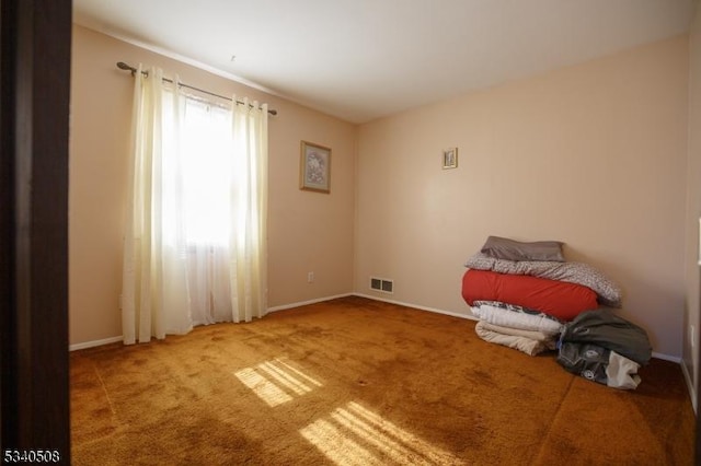 interior space with baseboards, visible vents, and carpet flooring