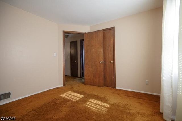 carpeted empty room with visible vents and baseboards