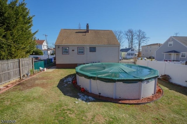 view of swimming pool featuring a yard, a fenced backyard, and a fenced in pool