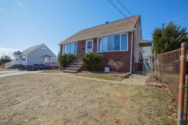 view of front of house with fence, a front lawn, and brick siding