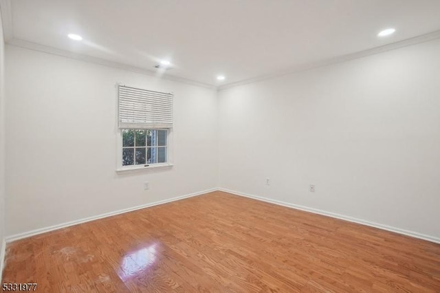 empty room with crown molding, baseboards, and wood finished floors