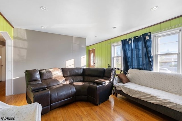 living area with wooden walls, wood finished floors, and recessed lighting