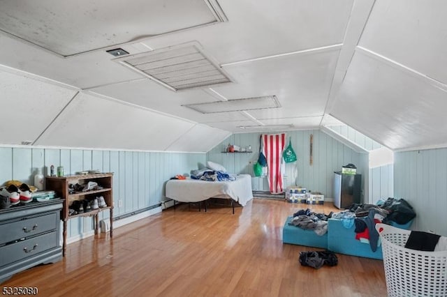 bonus room with lofted ceiling, a baseboard heating unit, and wood finished floors