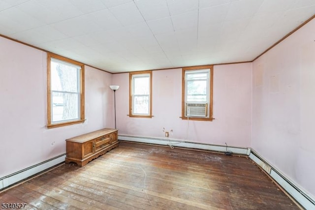 unfurnished room featuring a baseboard heating unit, cooling unit, and wood-type flooring