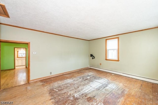 empty room with crown molding, a textured ceiling, wood-type flooring, and a baseboard radiator