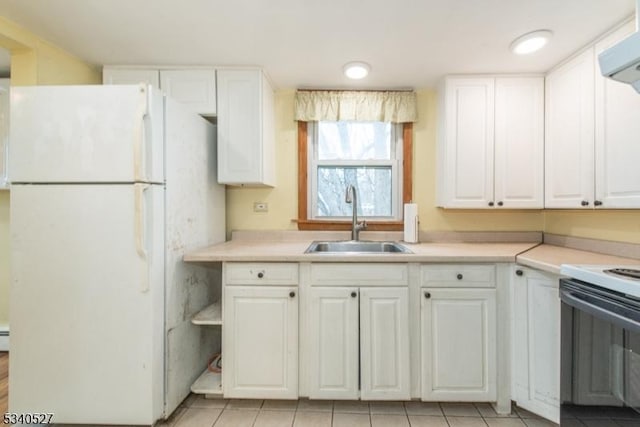 kitchen featuring a sink, range hood, electric range oven, freestanding refrigerator, and white cabinets