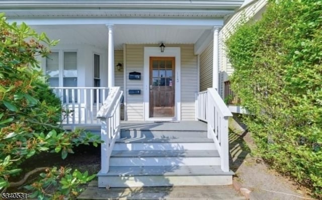 view of exterior entry with a porch