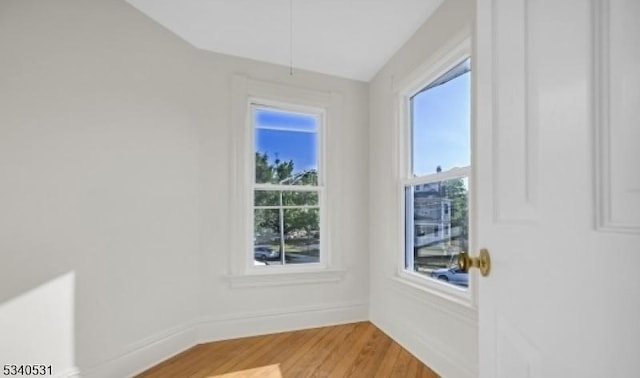 spare room featuring light wood-style floors and baseboards